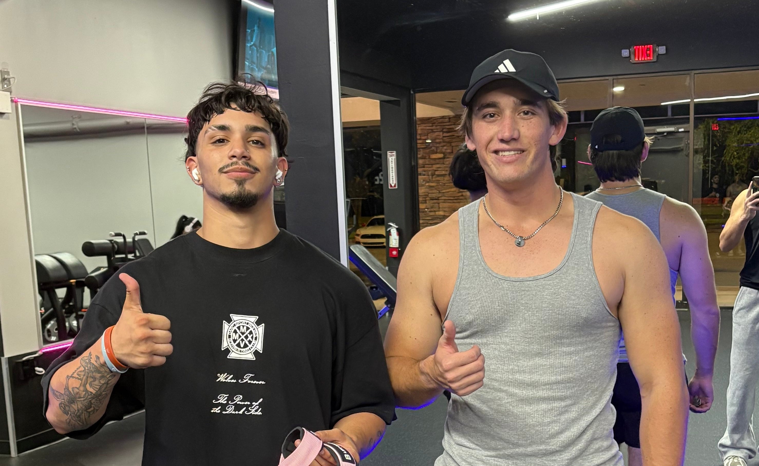 Two men giving thumbs up in a gym setting