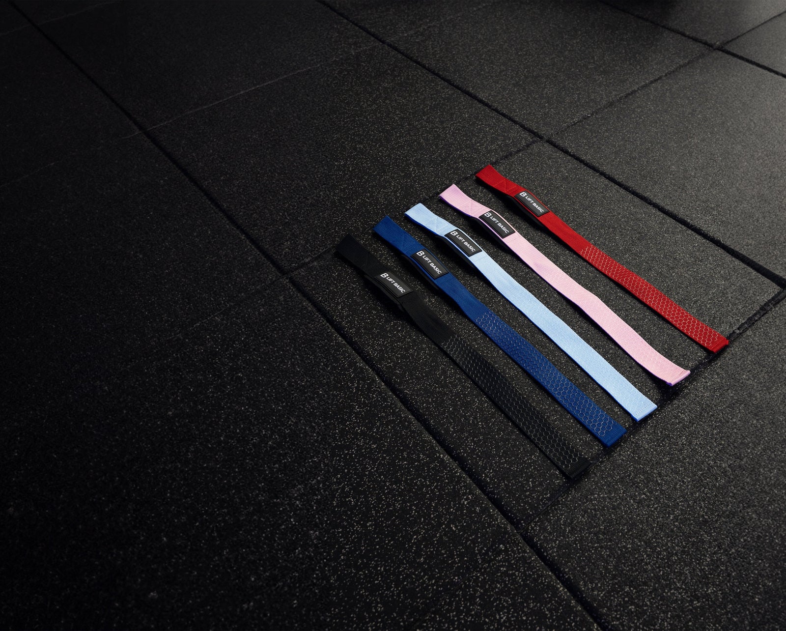 Set of colorful lifting straps on a dark tiled floor