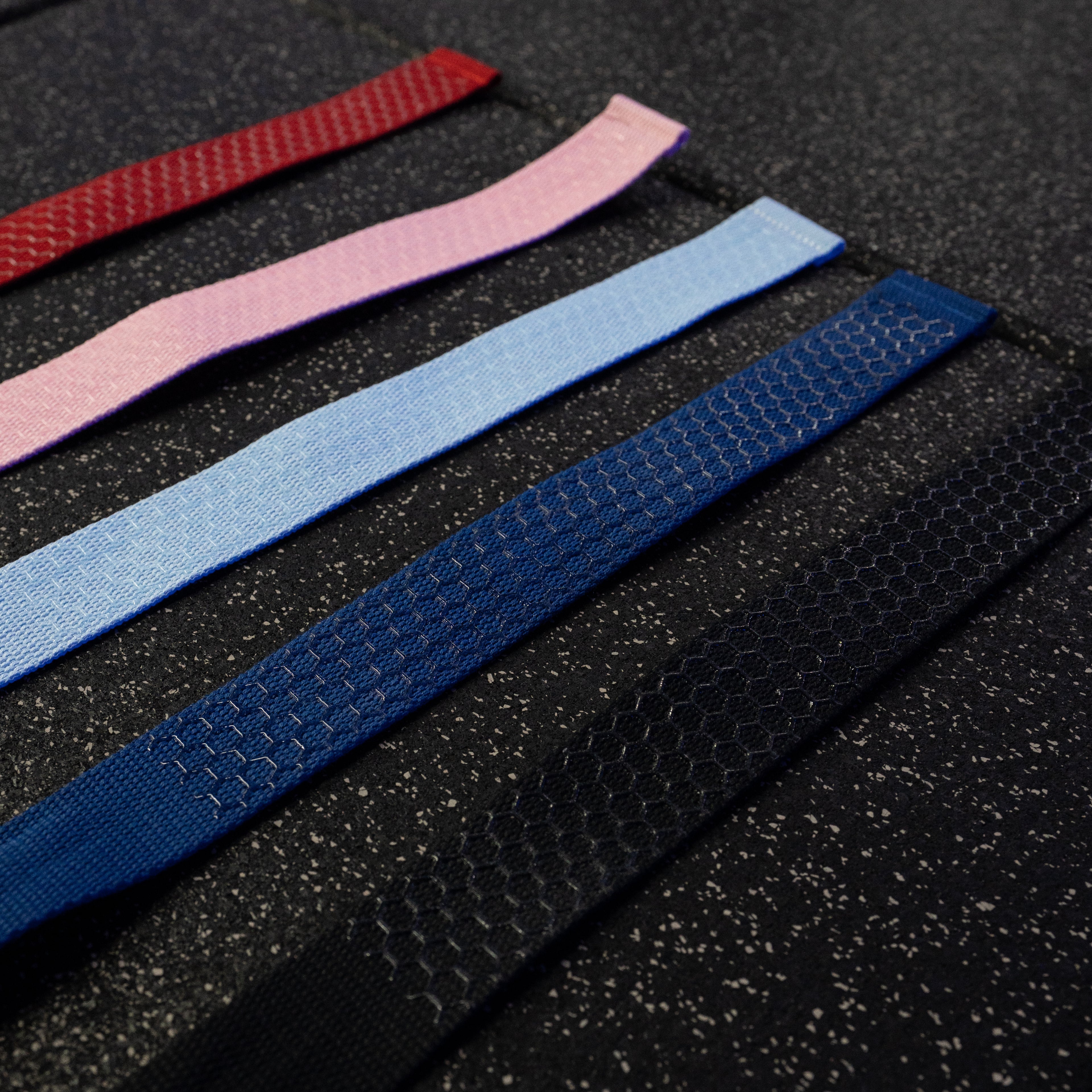 Set of colorful lifting straps on a textured black surface
